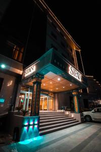 Sipan Hotel في أربيل: مبنى عليه لافته في الليل