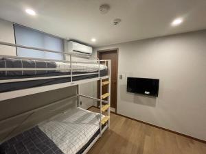 a room with bunk beds and a flat screen tv at Hao Guesthouse in Hongdae in Seoul