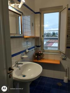 ein Bad mit einem Waschbecken und einem Fenster in der Unterkunft IDA S Apartament in Pontecagnano