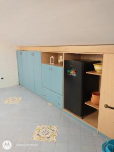 a kitchen with blue cabinets and a black refrigerator at IDA S Apartament in Pontecagnano