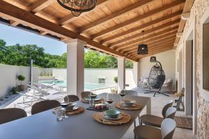 a dining room with a table and chairs on a patio at Casa Evina in Krnica