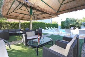 un patio con sillas y una mesa bajo una sombrilla de paja en Villa Tade en Debeljak
