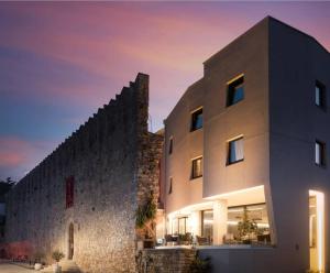 a building with a stone wall next to at Hotel Cittar in Novigrad Istria