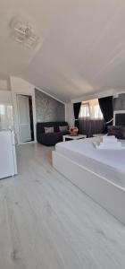 エフォリエ・スドにあるVila Blissの白いベッドルーム(大型ベッド1台、ソファ付)