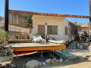 a house with a deck with a bench and a table at Casa Náutica Beach Guesthouse for Kiters & Surfers in Los Órganos
