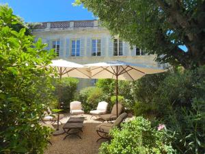 a patio with chairs and an umbrella in front of a building at Le Clos Saluces in Avignon