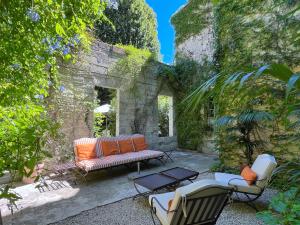 a patio with a couch and chairs in a yard at Le Clos Saluces in Avignon