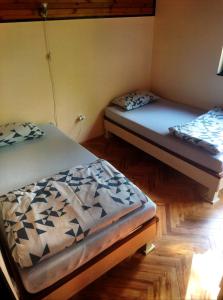 two twin beds in a room with wooden floors at Kuca za odmor Zlatibor in Zlatibor