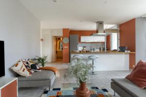 a living room with two couches and a kitchen at SIROCCO - Bel appartement avec extérieur proche des plages in Marseille