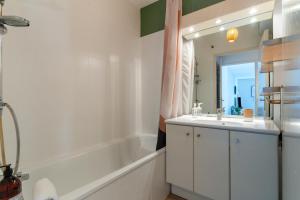 a bathroom with a tub and a sink and a mirror at SIROCCO - Bel appartement avec extérieur proche des plages in Marseille