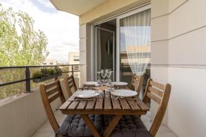 a wooden table on the balcony of a house at SIROCCO - Bel appartement avec extérieur proche des plages in Marseille