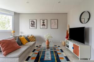 a living room with a couch and a tv at SIROCCO - Bel appartement avec extérieur proche des plages in Marseille
