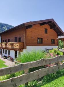 ein Holzhaus mit einem Zaun davor in der Unterkunft Apartment Ferienhaus Seidlgut in Wagrain