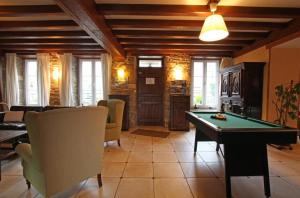 a living room with a pool table and chairs at GITE DU HABLE in Omonville-la-Rogue