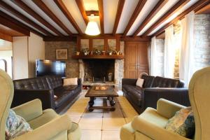 a living room with leather couches and a fireplace at GITE DU HABLE in Omonville-la-Rogue