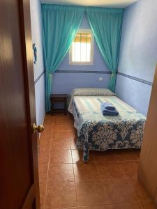 a small bedroom with a bed and a window at Villa Caramelo in Castril