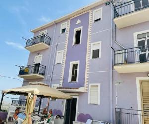 a purple building with an umbrella in front of it at Collina di Girgenti in Agrigento