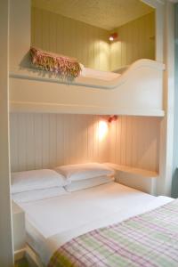 a bedroom with two beds and shelves on the wall at The Rocks at Plas Curig Hostel in Capel-Curig