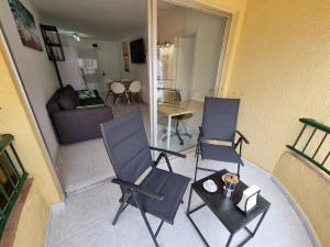 two chairs and a table in a living room at Torres del Sol 12th floor Teide and Atlantic view - Las Americas in Playa de las Americas +14 photos
