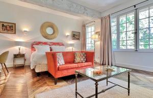 a living room with a bed and a red chair at Le Clos Saluces in Avignon