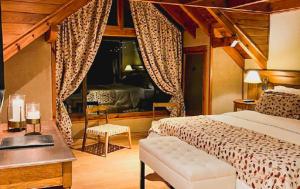a bedroom with a bed and a desk and a window at Dos Bahias Lake Resort in Villa La Angostura