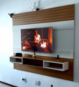 een televisie aan een muur in een woonkamer bij Lindo Ap Praia da Costa com Ar Condicionado in Vila Velha