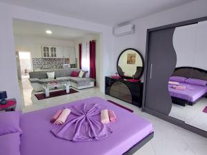 sala de estar con cama morada en una habitación en Apartmani Jovan, en Ulcinj