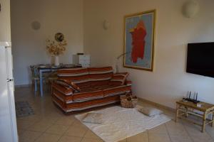 a living room with a couch and a table at Casa rosa dei venti in Pula