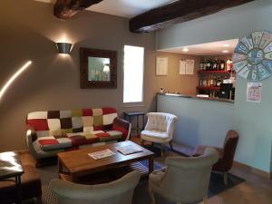 ein Wohnzimmer mit einem Sofa, Stühlen und einer Bar in der Unterkunft Logis Hotel Restaurant la Ferme in Avignon