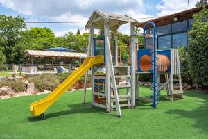 a childrens playground with a slide and a play structure at Nofesh Baharim in Ramot Naftali
