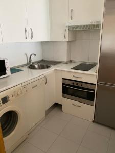 cocina blanca con fregadero y lavavajillas en Apartment close to Airport, Ifema, en Madrid