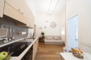 una cocina con fregadero y un sofá en una habitación en Principi Apartment, en Florencia