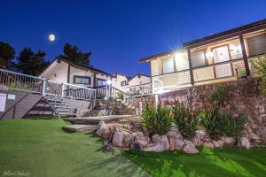 a house with a yard with flowers and rocks at Nofesh Baharim in Ramot Naftali