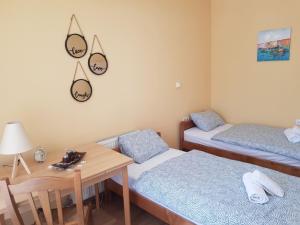 Cette chambre comprend deux lits, une table et un bureau. dans l'établissement Apartment Studenac, à Banja Luka