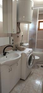 a white bathroom with a sink and a washing machine at Apartments Maja in Split