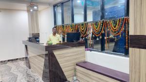 a man standing at a counter in a room at Hotel City View in Bhubaneshwar