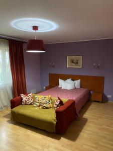 a bedroom with a large bed and a couch at Country Club La Mesteceni in Sebeş +29 photos