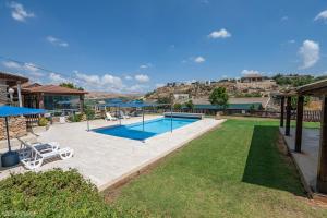a swimming pool in a yard with a house at Nofesh Baharim in Ramot Naftali
