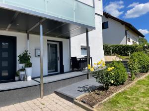 a house with a glass facade with a patio at Elida in Burgrieden