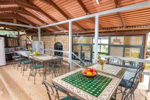 a patio with tables and chairs with a bowl of fruit at Nofesh Baharim in Ramot Naftali