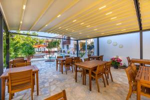 a restaurant with wooden tables and chairs and a patio at Elizya Boutique Hotel in Selimiye