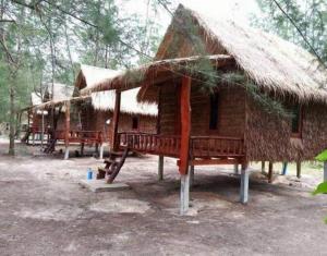 Cabaña pequeña con techo de paja en un bosque en Rakkan Resort en Ko Phra Thong
