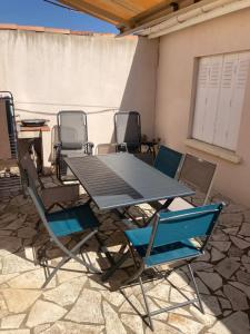 einen Tisch und Stühle auf einer Terrasse in der Unterkunft Gîte domaine de la source bas in Vias