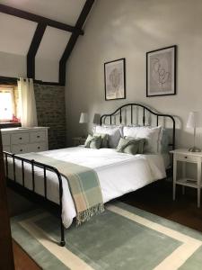 een slaapkamer met een groot bed met witte lakens en kussens bij La Paix, Gîte bucolique en Normandie in Condé-sur-Noireau