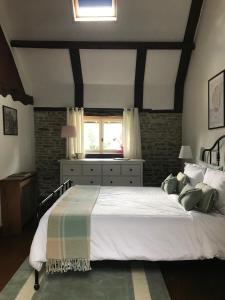 een slaapkamer met een groot wit bed en een raam bij La Paix, Gîte bucolique en Normandie in Condé-sur-Noireau