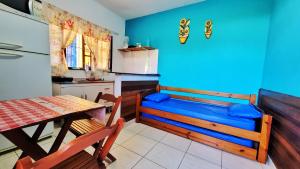 a kitchen with a table and a blue wall at Bardul´s House in Ubatuba