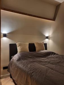 a bed in a bedroom with two lights on the wall at Super de luxe privékamer op een toplocatie - Room 2 in Egmond aan Zee