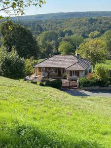 una casa en una colina con un campo de hierba en Claire fontaine en Beaumont-du-Périgord