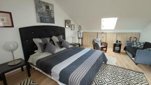 a bedroom with a large bed and a couch at Duplex contemporain terrasse extérieure parking in Lèves