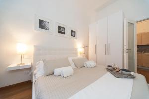 フィレンツェにあるプリンチピ アパートメントの白いベッドルーム(白いシーツを使用した大型ベッド1台付)